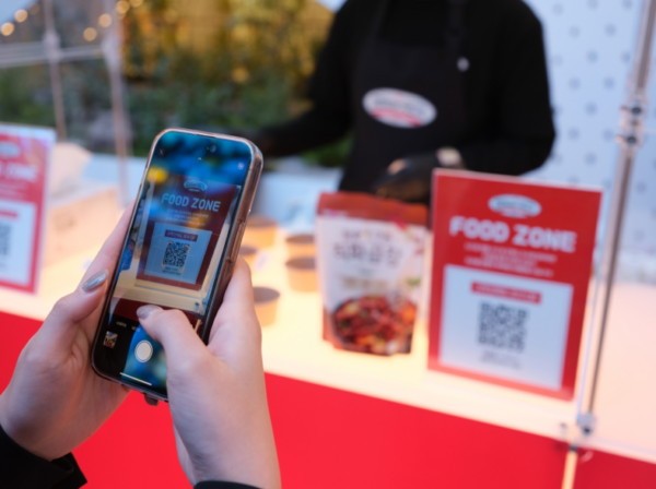 2025 도드람 페스타 팝업스토어 시식존 만족도 조사 QR코드를 스캔 중인 고객